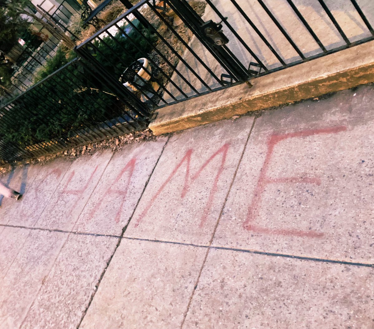 SHAME is scrawled in spray paint on the sidewalk in front of the Belarusian embassy in D.C