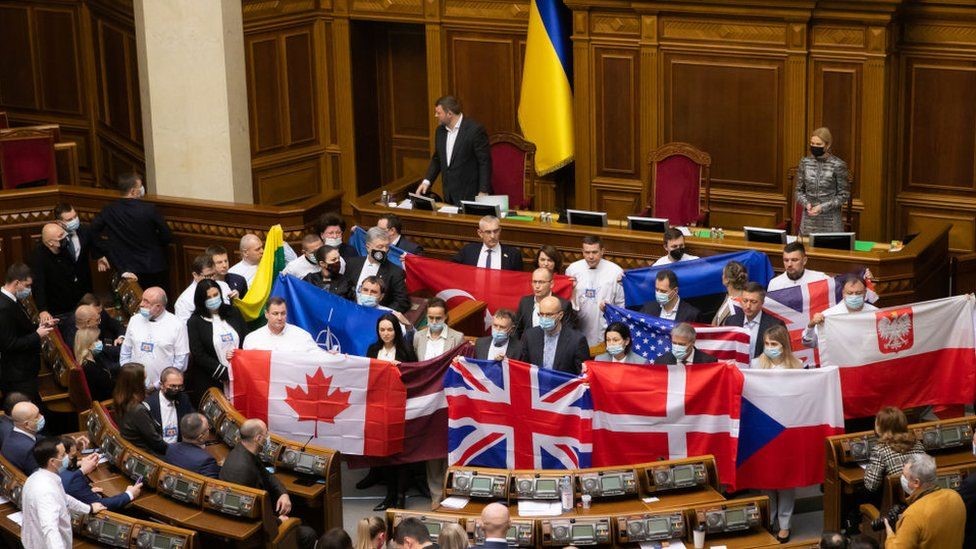 Ukrainian MPs holding up flags of countries that have offered help to Ukraine
