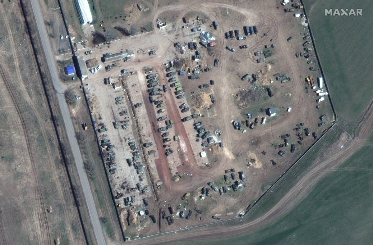 Satellite imagery of Kherson Airbase shows buildup of Russian forces with dug in positions. Some vehicles appear to be marked with the Z symbol. Location: 46.676, 32.508